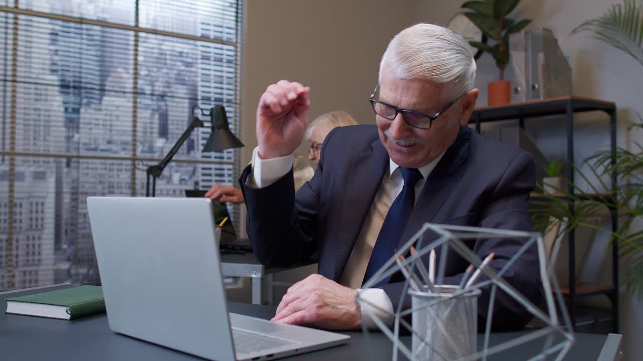 노트북으로 일하고, 웃고, 승리를 축하하는 즐거운 고위 비즈니스 회사 관리자