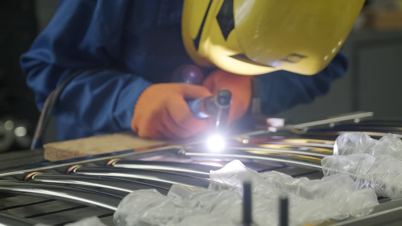 Man wearing mask welding in a workshop. Metal workers use manual labor. Skilled welder. Welder is welding the stainless steel pipes in the factory. welder Industrial part in factory.