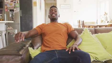 african american man siting in sofa looking at the camera and smiling