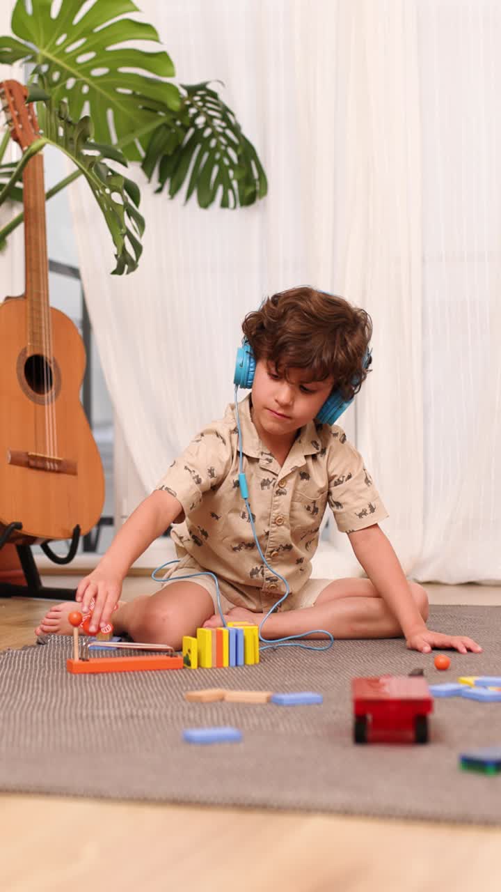 Child playing with educational toy and listening music with headphones