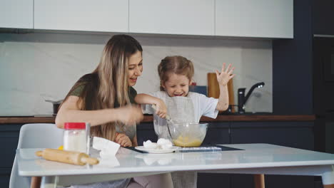 niña en la cocina en la mesa en una placa de vidrio profundo