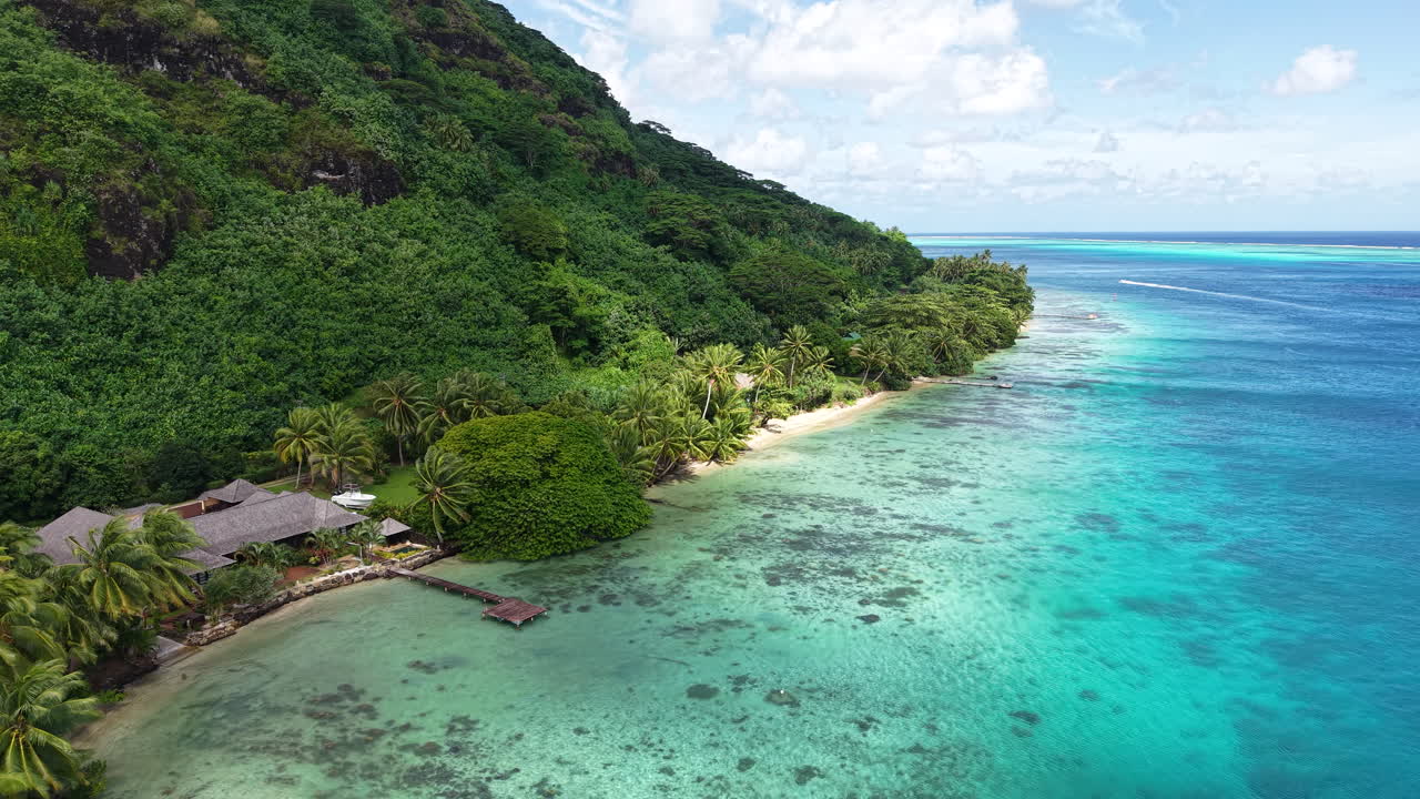 Huahine Island, French Polynesia. Drone View of Serene Beach, Clouds Shadows Above Landscape and Beachfront Homes