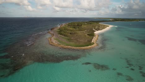 A scenic aerial view of a tropical island with lush greenery, turquoise waters, and sandy beach