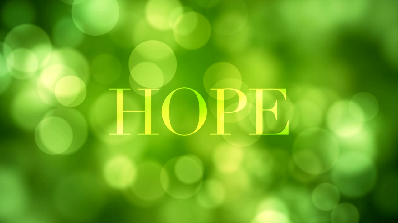Appearing 'Hope' text and dissolving after a while with moving green glitter lights, defocused light reflections on loopable green bokeh background. Healthy life, spring, forest, wishful concept video