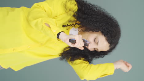 Vertical-video-of-The-young-woman-is-singing.