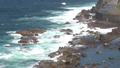 Hermosas-Olas-Azules-Del-Océano-Rompiendo-La-Costa-Rocosa