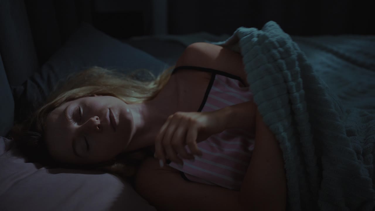 mujer durmiendo en la cama por la noche