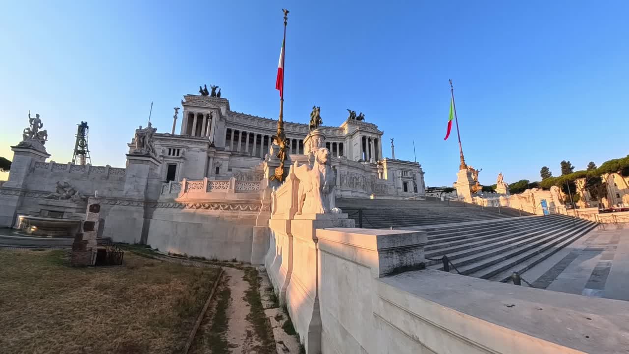 Primo piano del monumento a Vittorio Emanuele II a Roma, Italia, all'alba. Scalinate in marmo, statue di leoni ed edifici storici circostanti nel centro della città