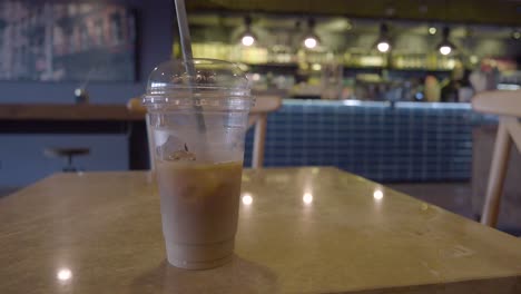 iced coffee in a plastic cup on a cafe table