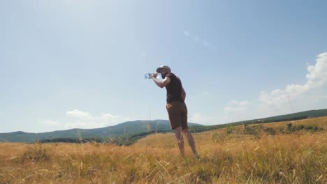 mountaineer drinks water from a plastic 2l bottle
