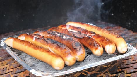 grilling sausages on disposable barbecue grid.