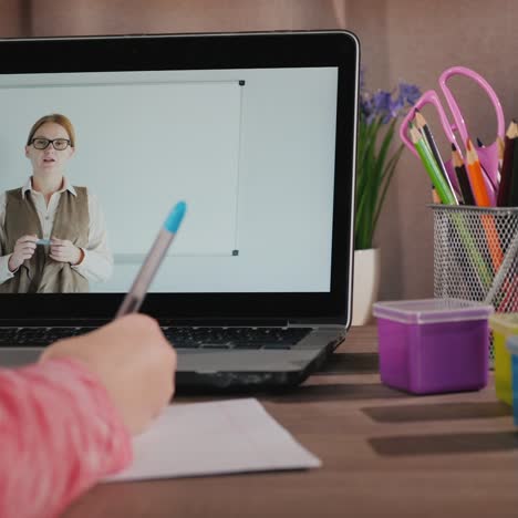 la niña da lecciones cerca de las clases de computadoras portátiles en línea durante la cuarentena y el autoaislamiento 1