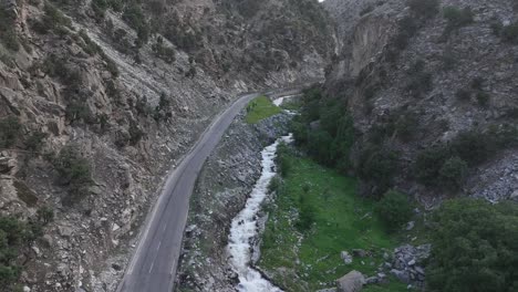 Aerial-drone-view-of-a-small-valley-with-a-road-alongside-the-river-and-fields---The-beautiful-valley-of-Chilas,-Pakistan