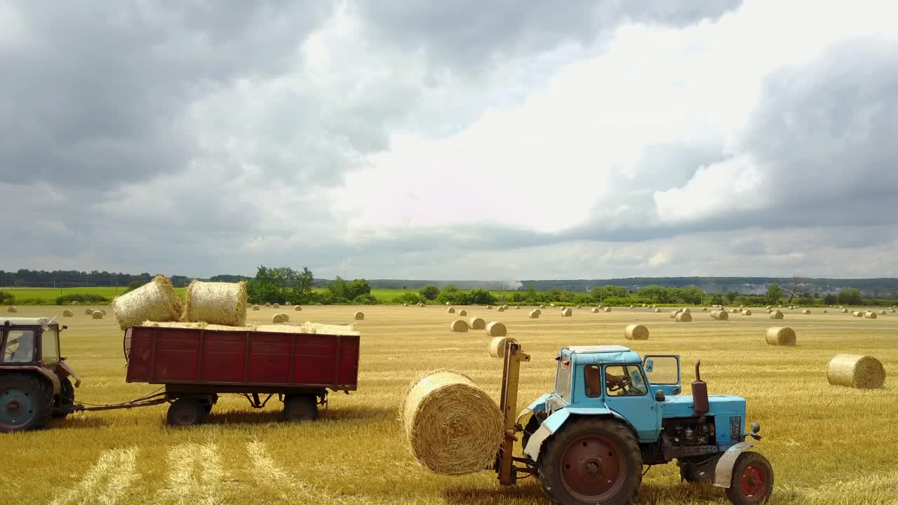 Semi Truck Loading Straw Bales. Semi truck and tractor loaded straw bales in countryside