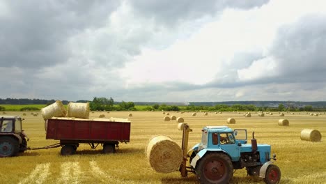 semi truck loading straw bales. semi truck and tractor loaded straw bales in countryside
