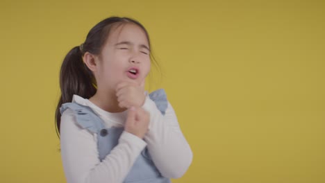 studio portrait of young girl thinking against yellow background