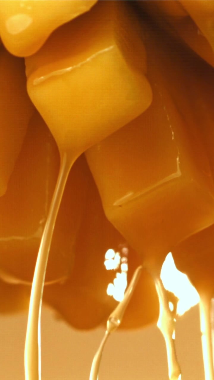 Salsa al caramello che cola su caramelle dolci al rallentatore