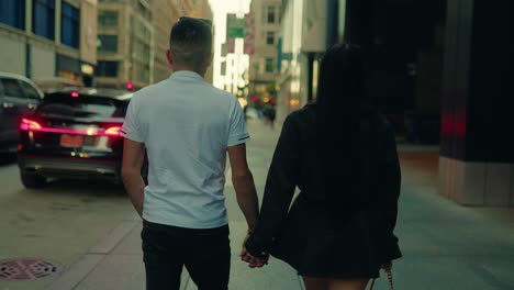 candid moment of a couple walking hand in hand through the city streets, chicago, illinois, usa