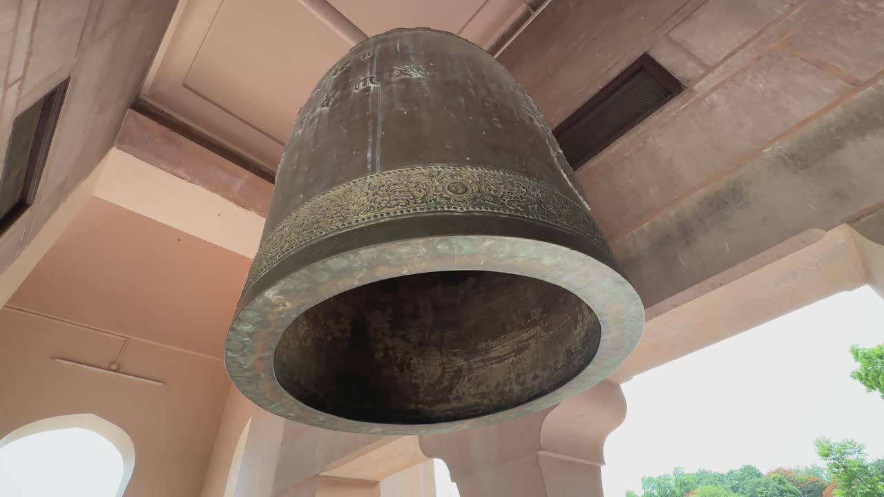 Primo piano di una campana di metallo fatta di ottone o bronzo appesa in un tempio buddista, usata per scopi religiosi e cerimoniali.