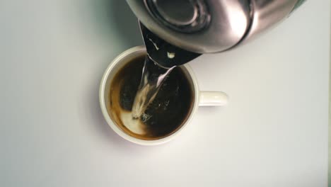 preparing a cup of black instant coffee