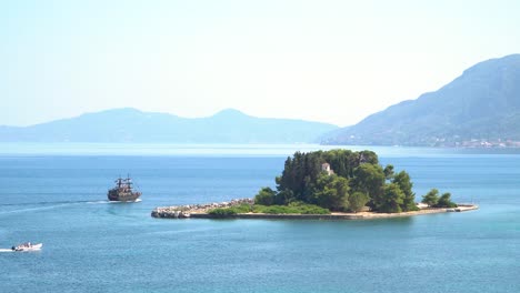 Tourist-Pirate-Ship-Approaches-Pontikonisi-Island-Corfu-Greece,-Panoramic-View-from-Kanoni-Kerkyra