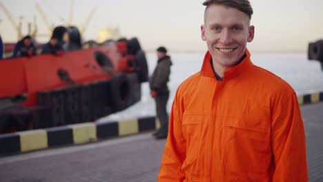 Dock-worker-in-orange-uniform-walking-in-the-harbor-and-controlling-working-process-in-the-port.