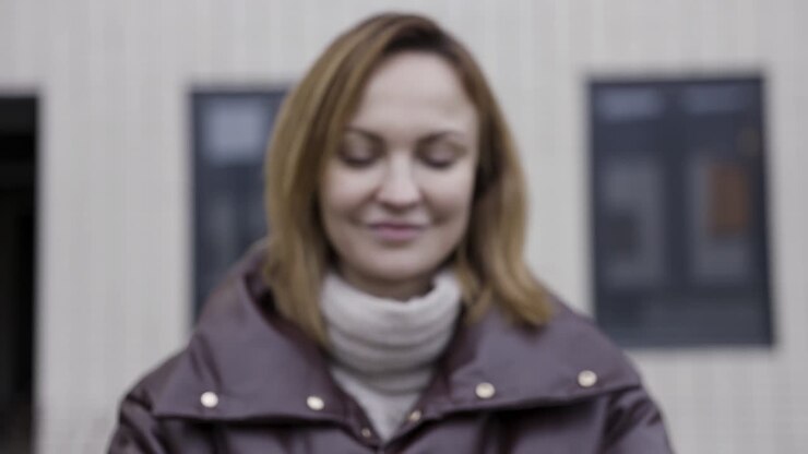 Donna con in mano un iPhone blu scuro