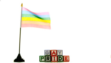 bandera del arco iris soplando en el viento al lado de los bloques de orgullo gay