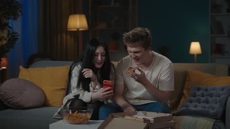 friends enjoying pizza and a video call at home