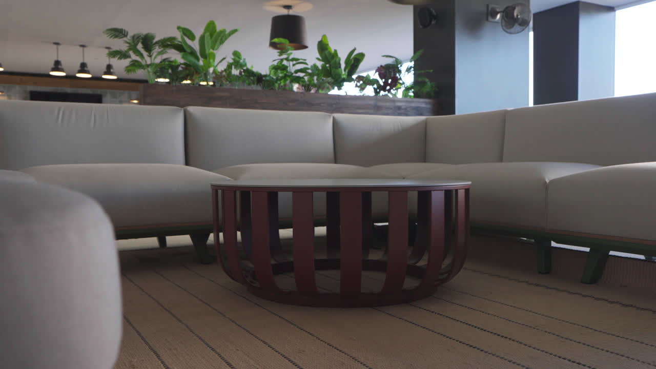 Modern U-Shaped Sofa with Round Wooden Coffee Table and Plants