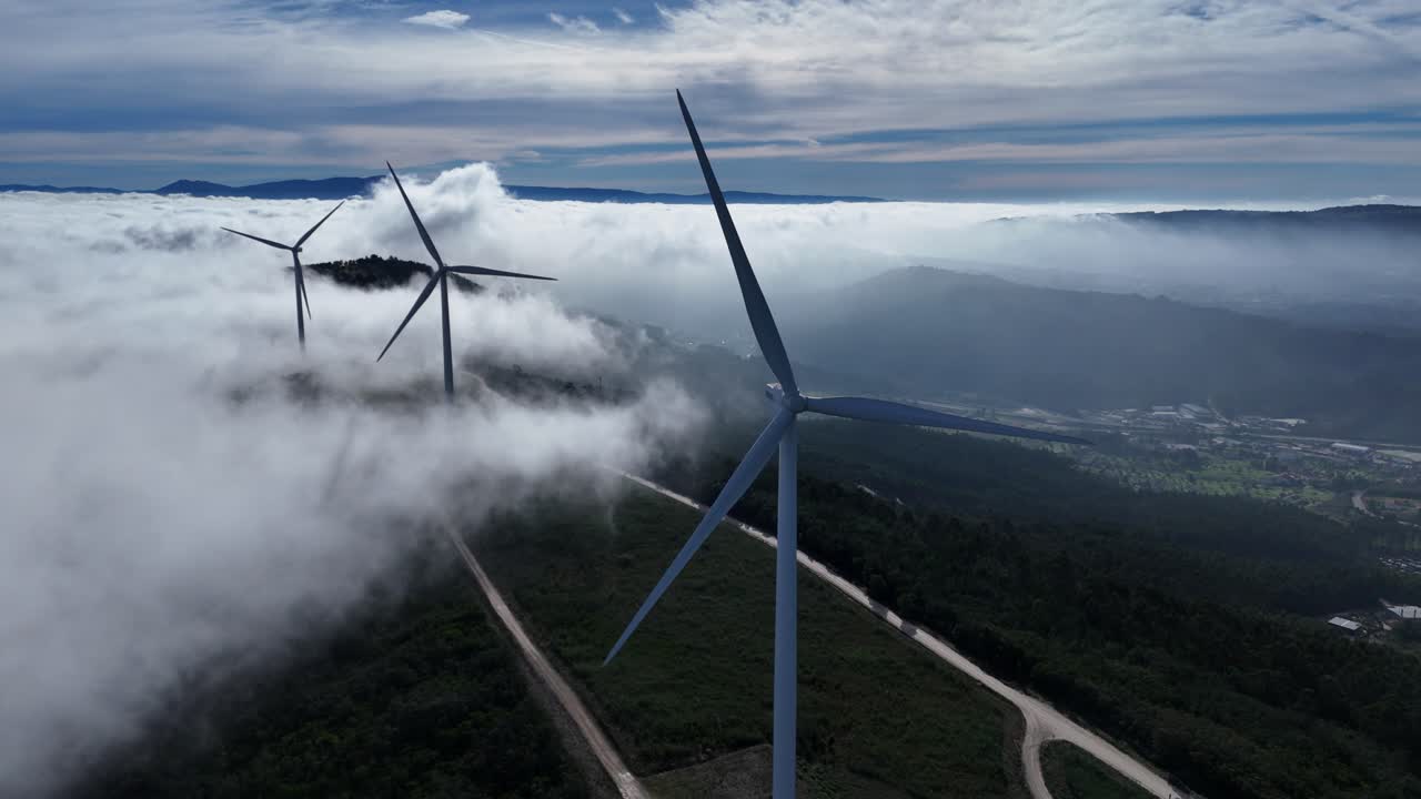 Wind turbines with clouds rolling over the mountain