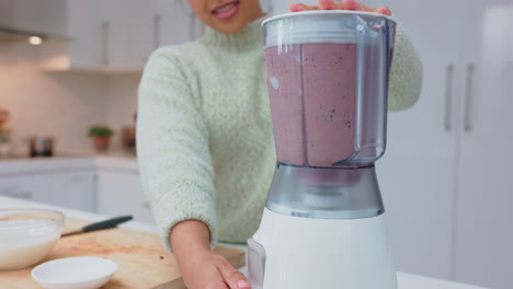 woman making a purple smoothie