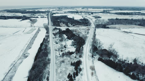 Flying-over-Beautiful-Snow-Covered-Railroad-Train-Tracks-in-Winter-Landscape