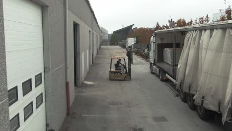 forklift loading and unloading a truck in an industrial zone