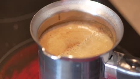 café turco elaborado en una olla de metal en una estufa