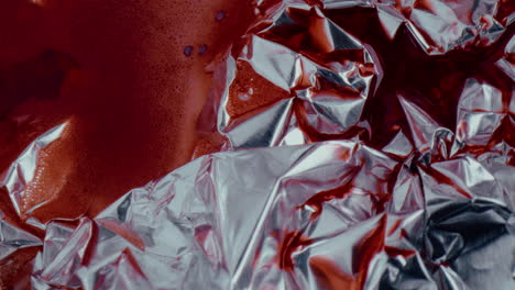 crumpled foil with red liquid