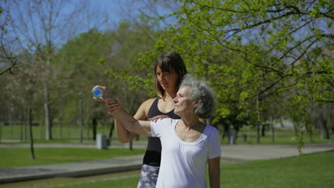 smiling elderly woman exercising with bottle of water.