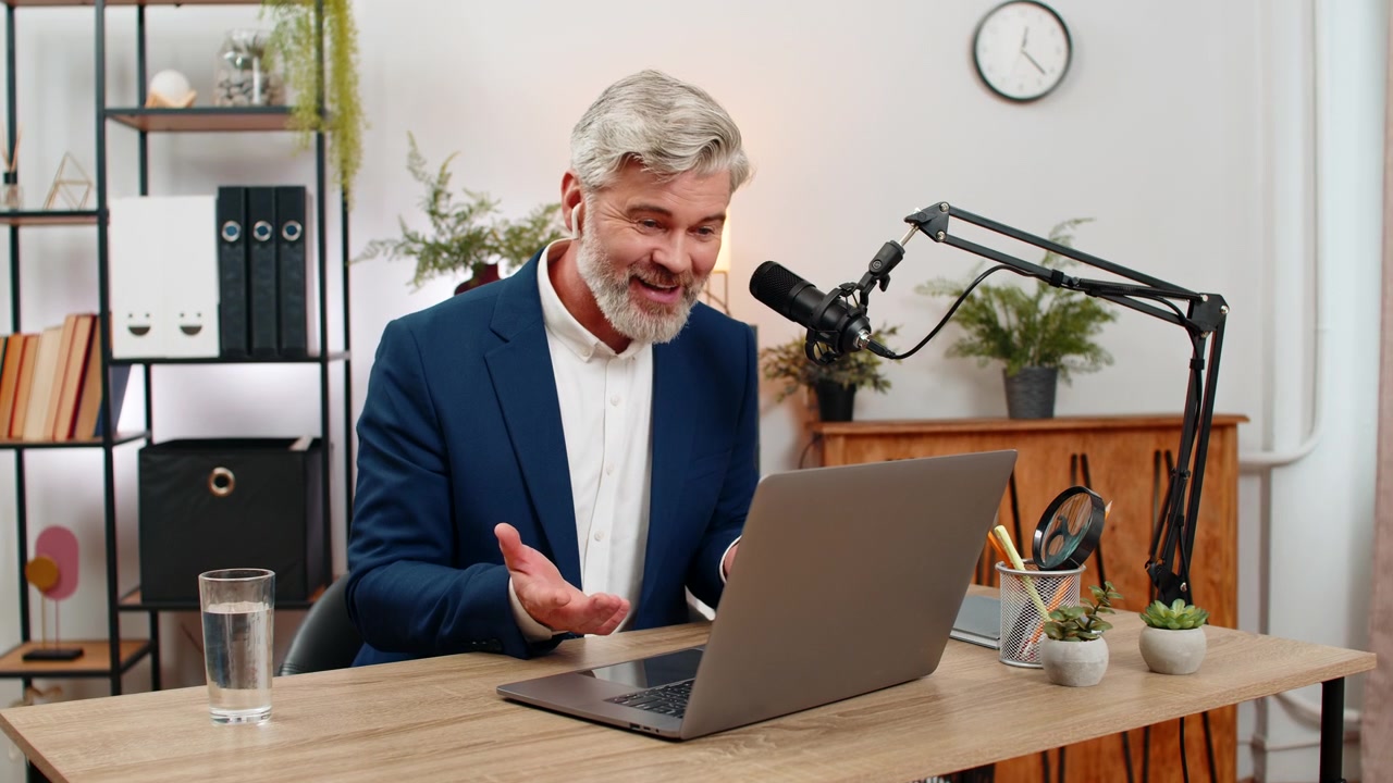 Forretningsmand er vært for podcast og taler i studiomikrofon med livlige gestikulationer og giver eksperttips