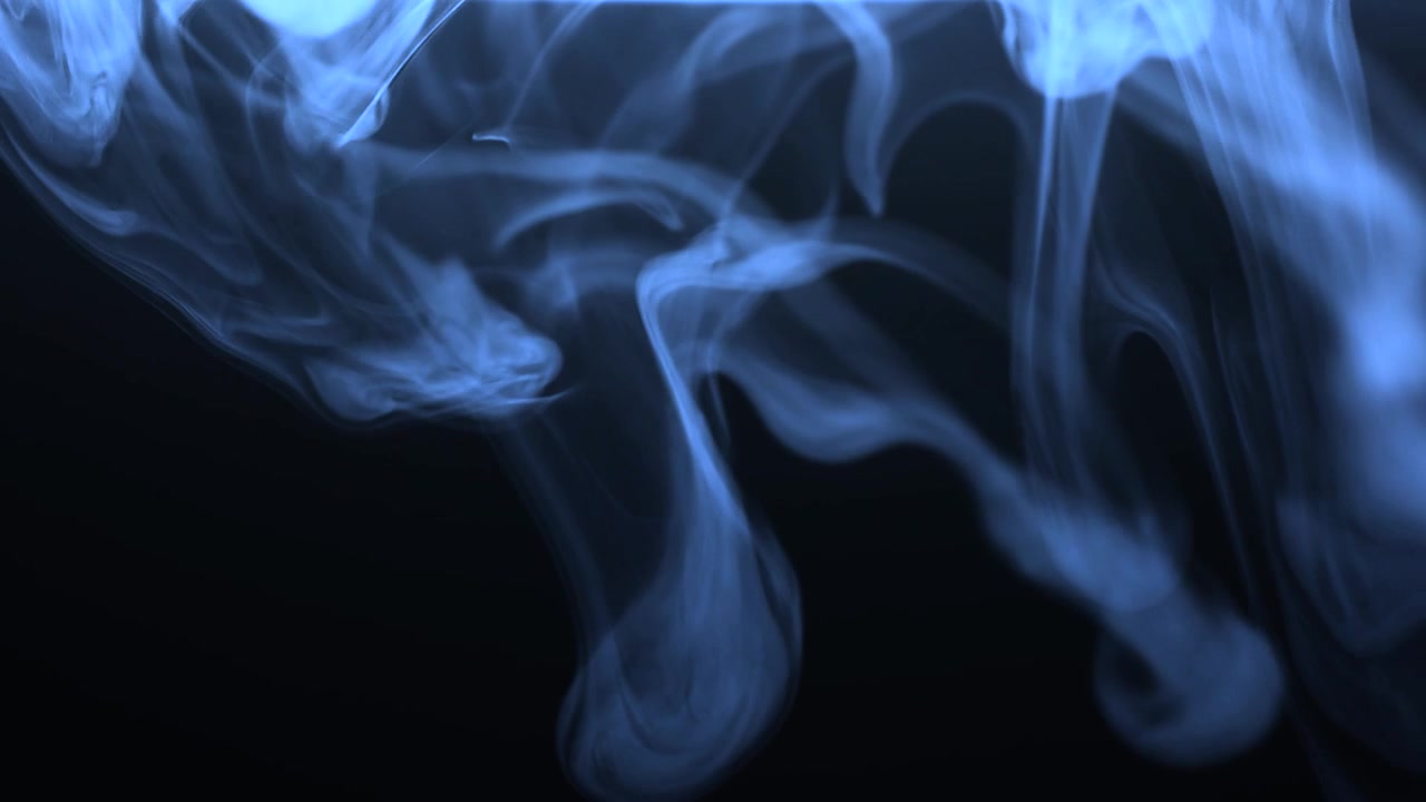 Fumo blu vorticoso in un ambiente scuro.