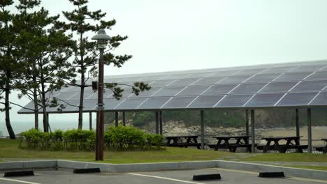 한국 바다 근처 창고 지붕에 설치된 태양 전지판 - 와이드 샷