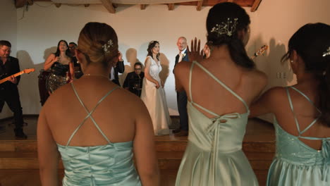 clip of a wedding where the newlyweds dance happily with their guests and bridesmaids.