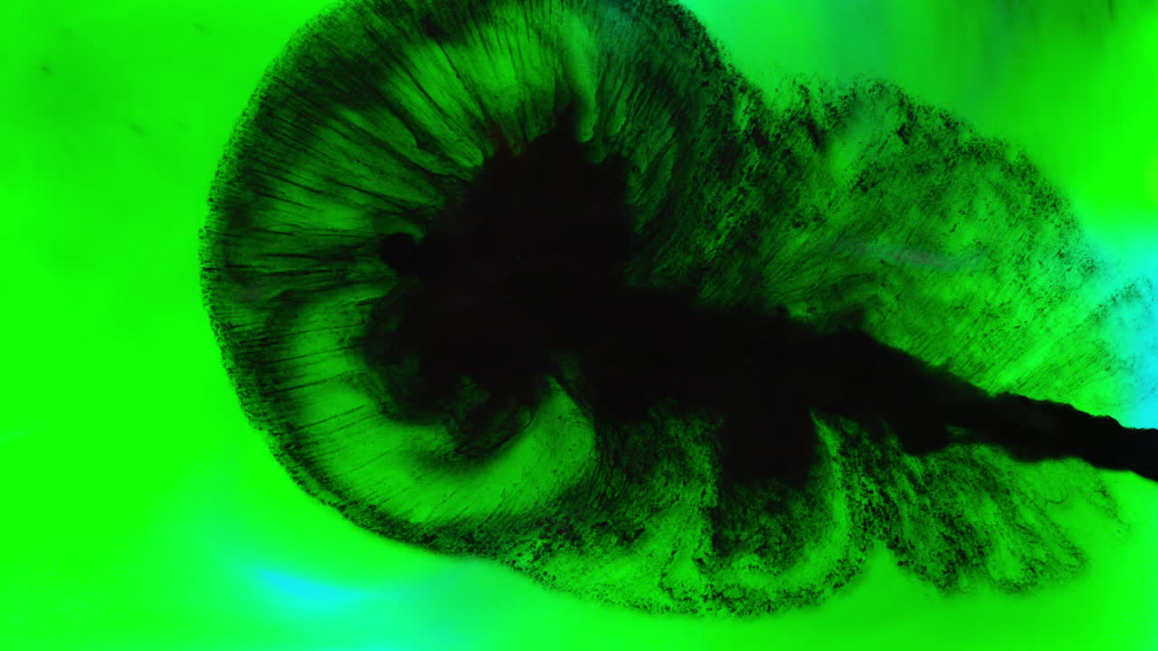 pintura o tinte negro y verde caído en el agua contra un fondo blanco para crear un fondo de humo de colores giratorios 2