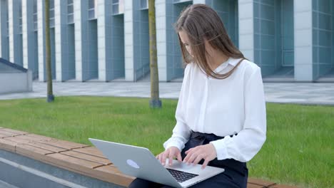 Verärgerte-Junge-Junge-Frau,-Die-Frustriert-Und-Grimassierend-Am-Laptop-Im-Büro-Im-Freien-Arbeitet