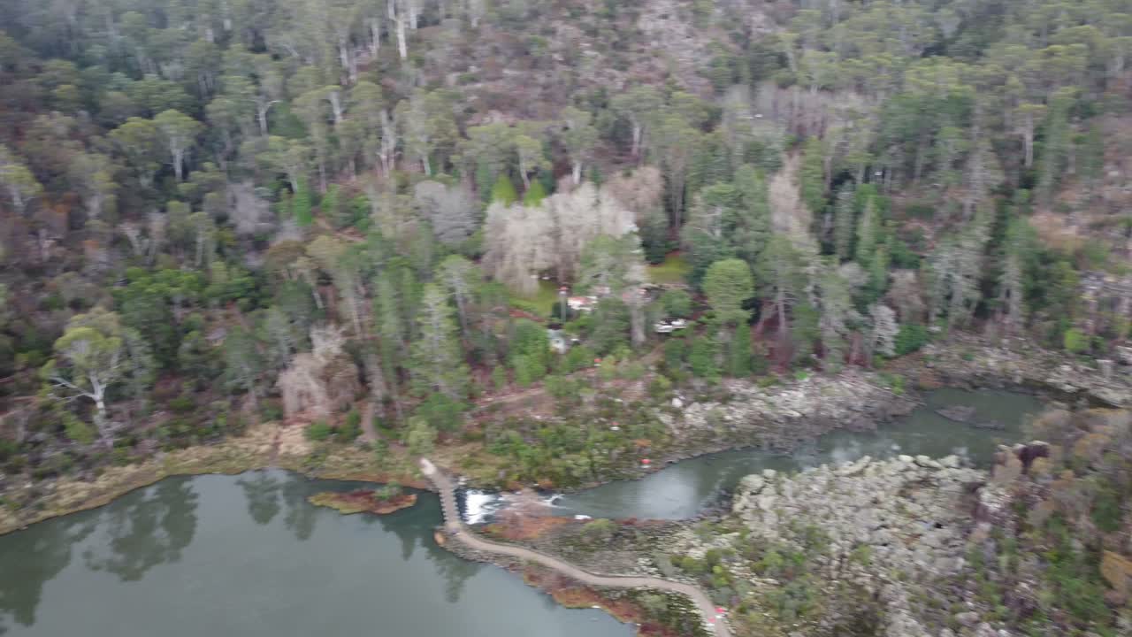 오스트레일리아 국립 공원의 산책로, 서스펜션 브릿지 및 작은 폭포가있는 협곡의 4k 항공 사진