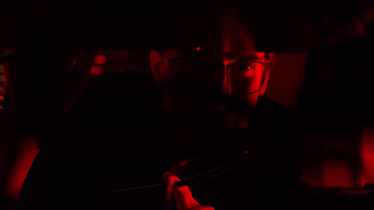 Man analysing servers in a data center with flashing red lights