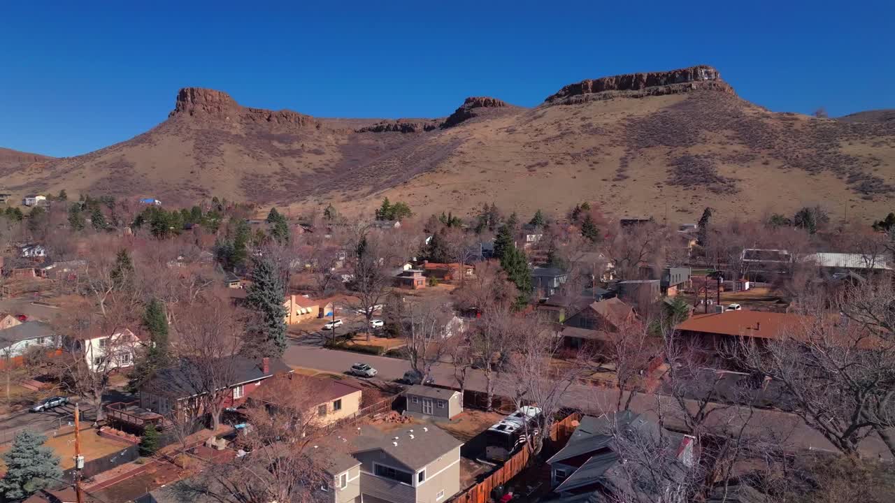 North Table Mountain Golden Colorado aerial drone Colorado historic downtown Golden Gate Canyon winter sunny morning afternoon blue sky Coors Beer Factory homes neighborhoods dead trees upwards