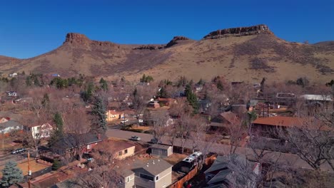 north table mountain golden colorado aerial drone colorado historic downtown golden gate canyon winter sunny morning afternoon blue sky coors beer factory homes neighborhoods dead trees upwards