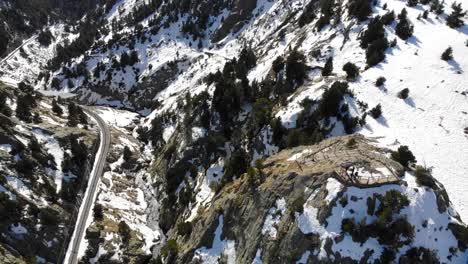 Aéreo:-Terreno-Montañoso-Con-Una-Vía-De-Tren,-Un-Río,-Algo-De-Nieve-Y-Un-Mirador-Con-Gente