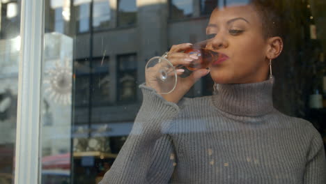 Mujer-Elegante-Sentada-En-La-Ventana-Del-Bar-Usando-El-Teléfono-Móvil