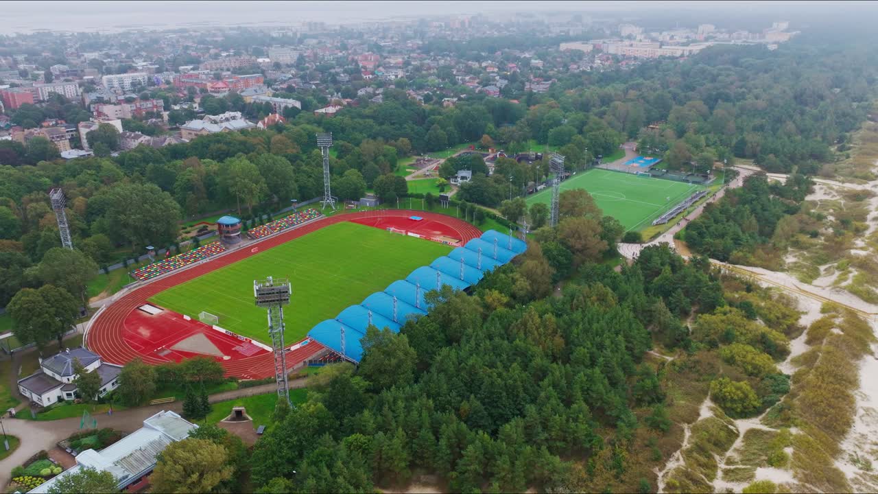 Drone berbelok ke kanan berfokus pada stadion Liepaja Daugava dan lapangan sekunder